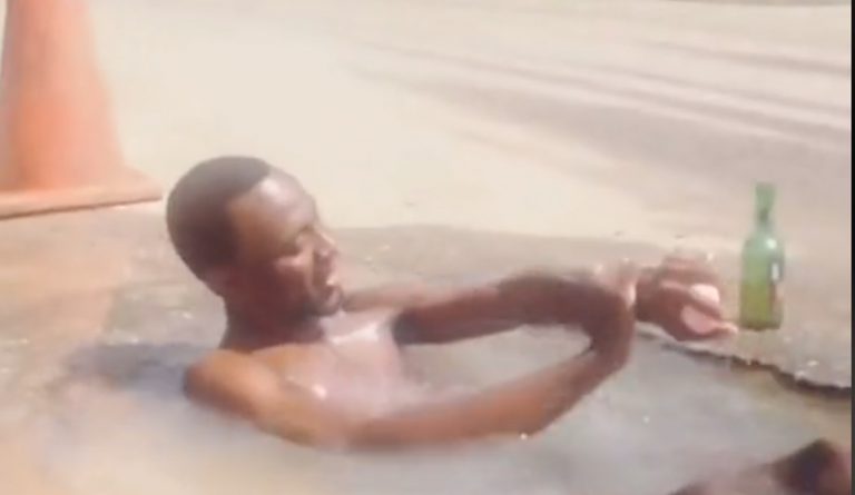 man bathing in a pothole